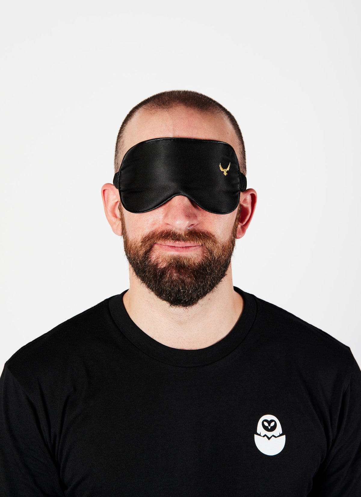 A bearded man wearing a 100% silk black eye mask from Melbourne video production company Enamoured Iris