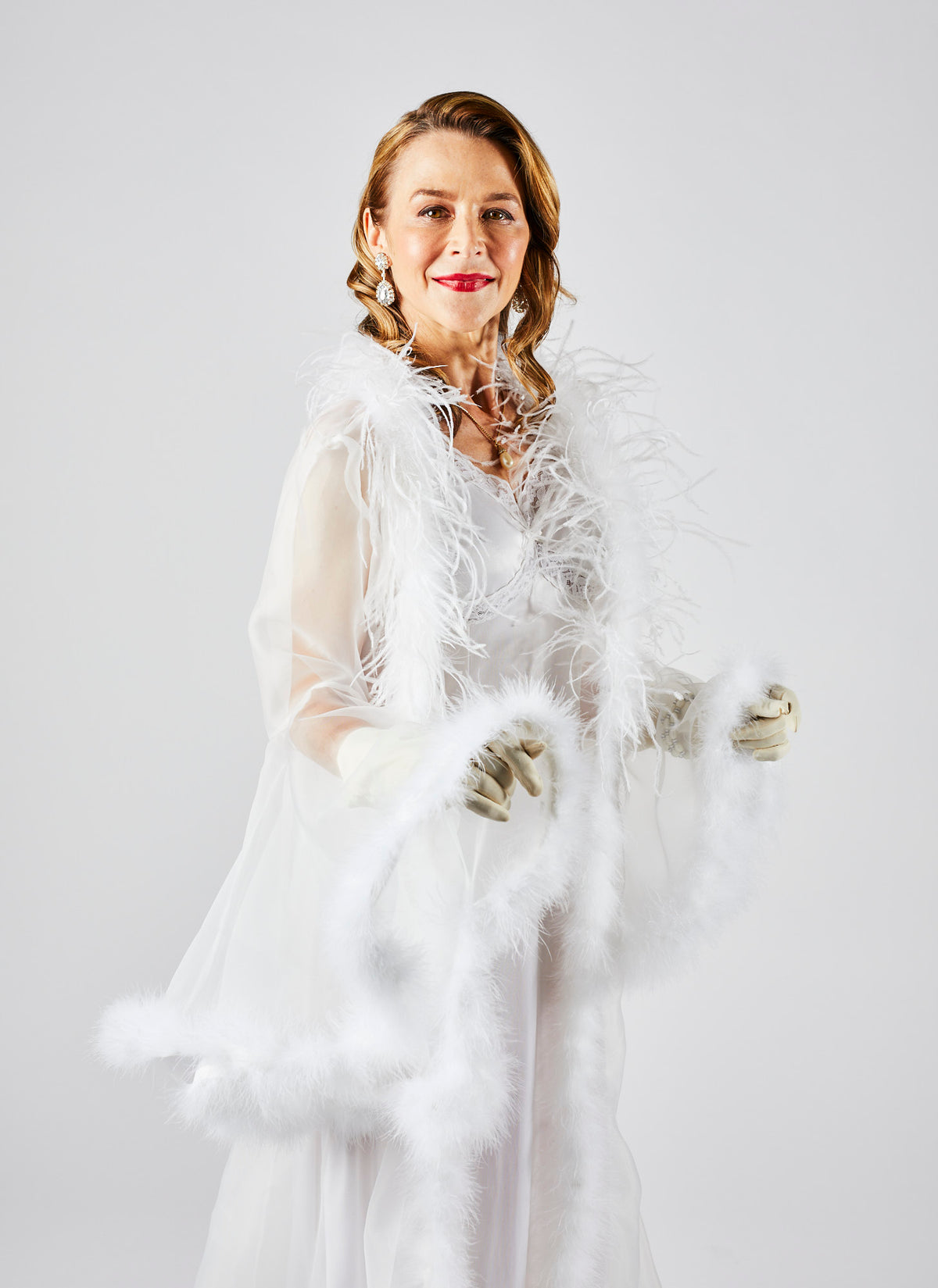 Side angle image of a rich woman wearing a White Video Production Gown in a Melbourne studio