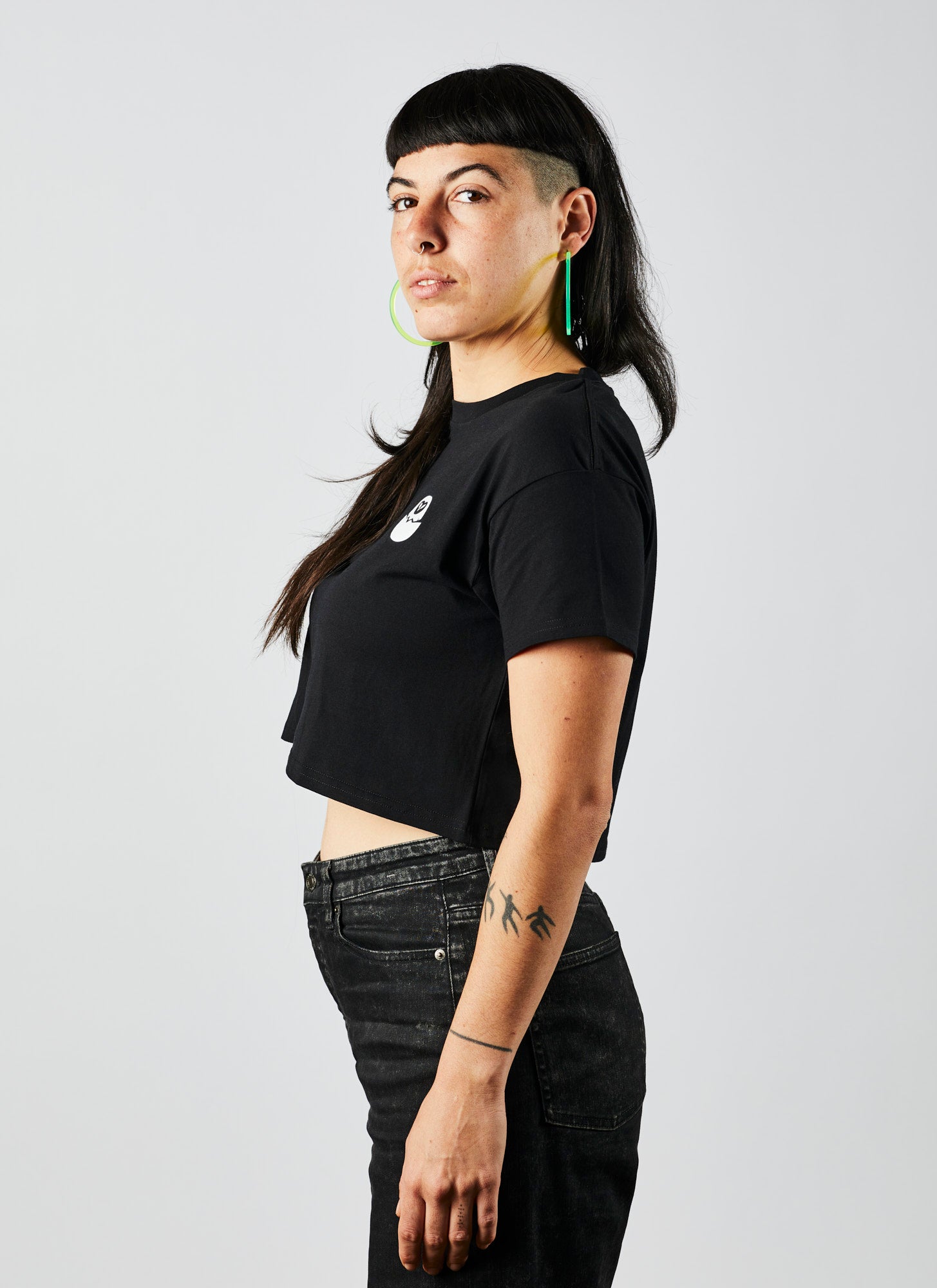 Front angle of a young woman wearing a black, crop Executive Producer shirt from Melbourne video production company, Enamoured Iris