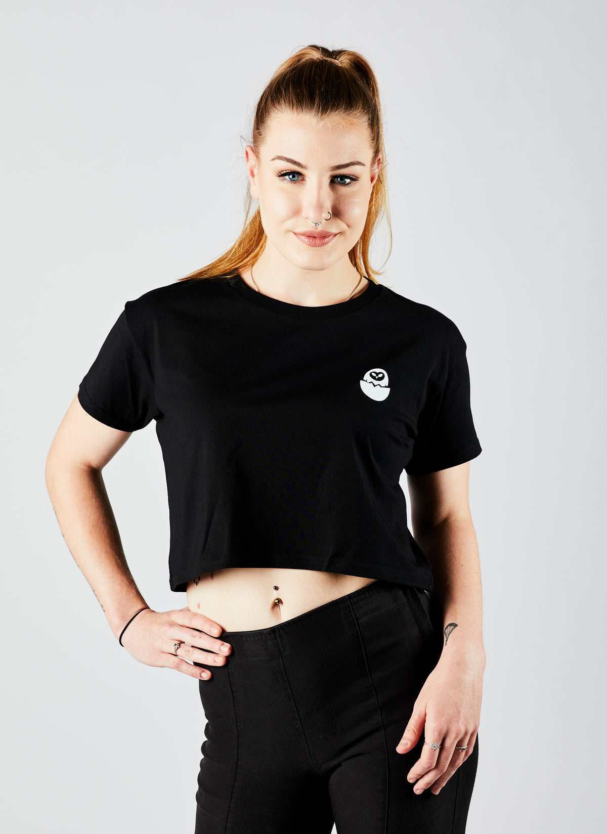 Front angle of a young woman wearing a black, crop &quot;Special Effects Supervisor&quot; shirt from Melbourne video production company, Enamoured Iris